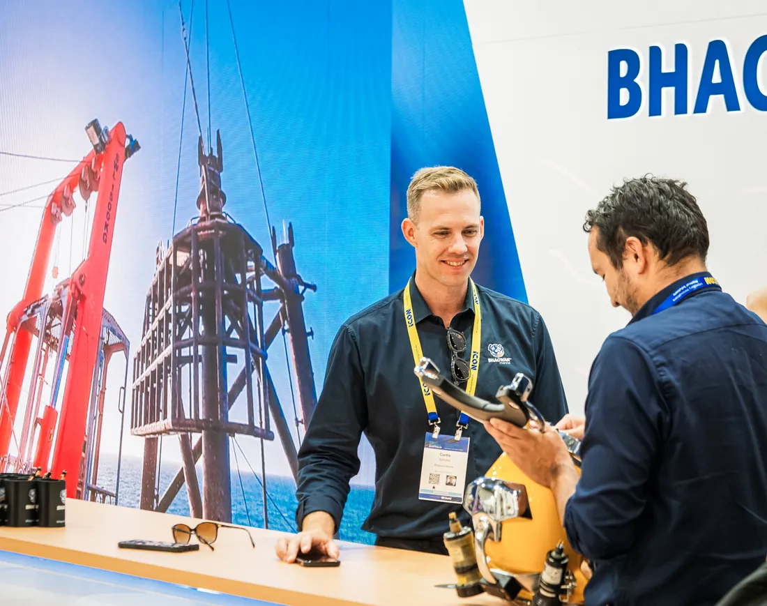 Exhibitor demonstrating a product to visitors at a trade show stand